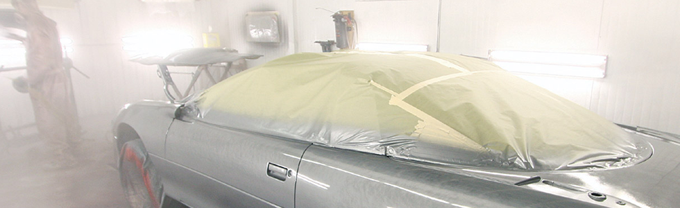 Spuitcabine met een auto in de masking